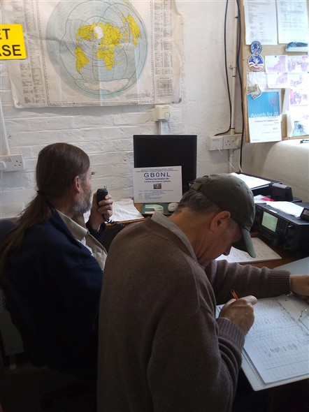 Photo:GB0NL on the air, with the operator on the mike and the call logger recording the details.
