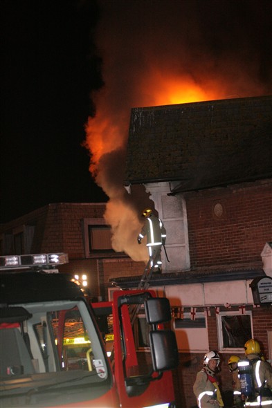 Photo:Fire fighter on the roof by the upstairs bar